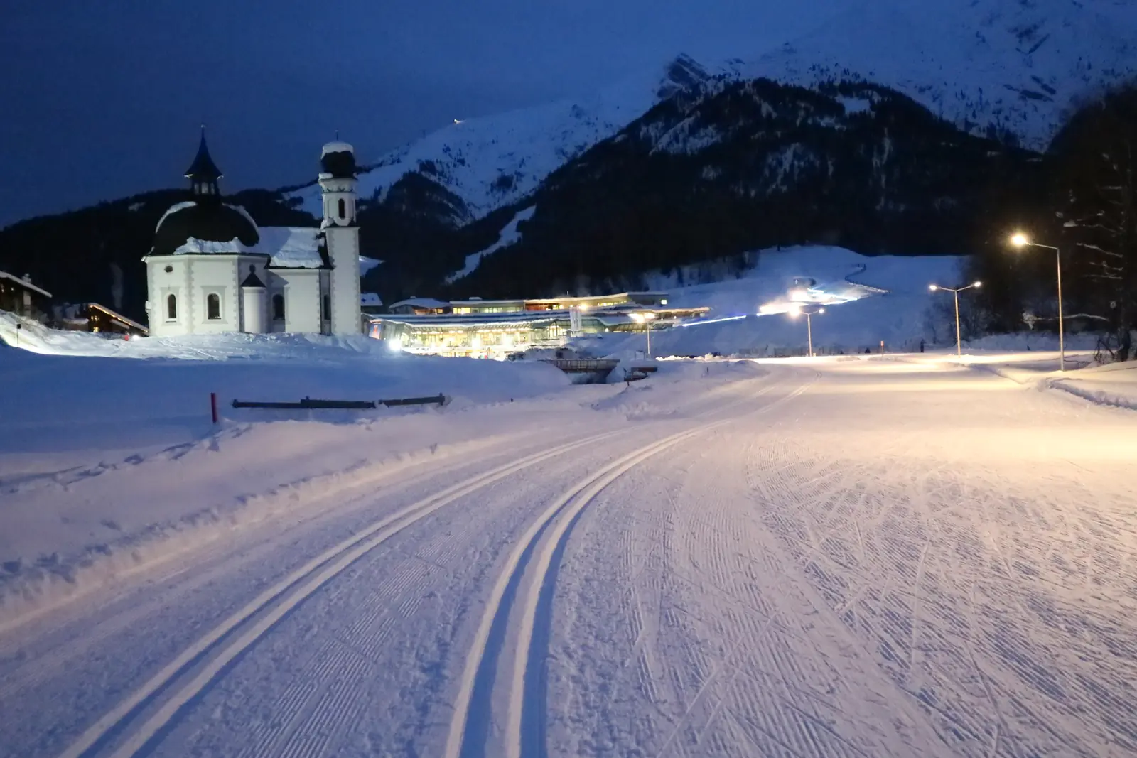 Beleuchtete Nachtloipe in Seefeld mit dem Seekirchl am Abend