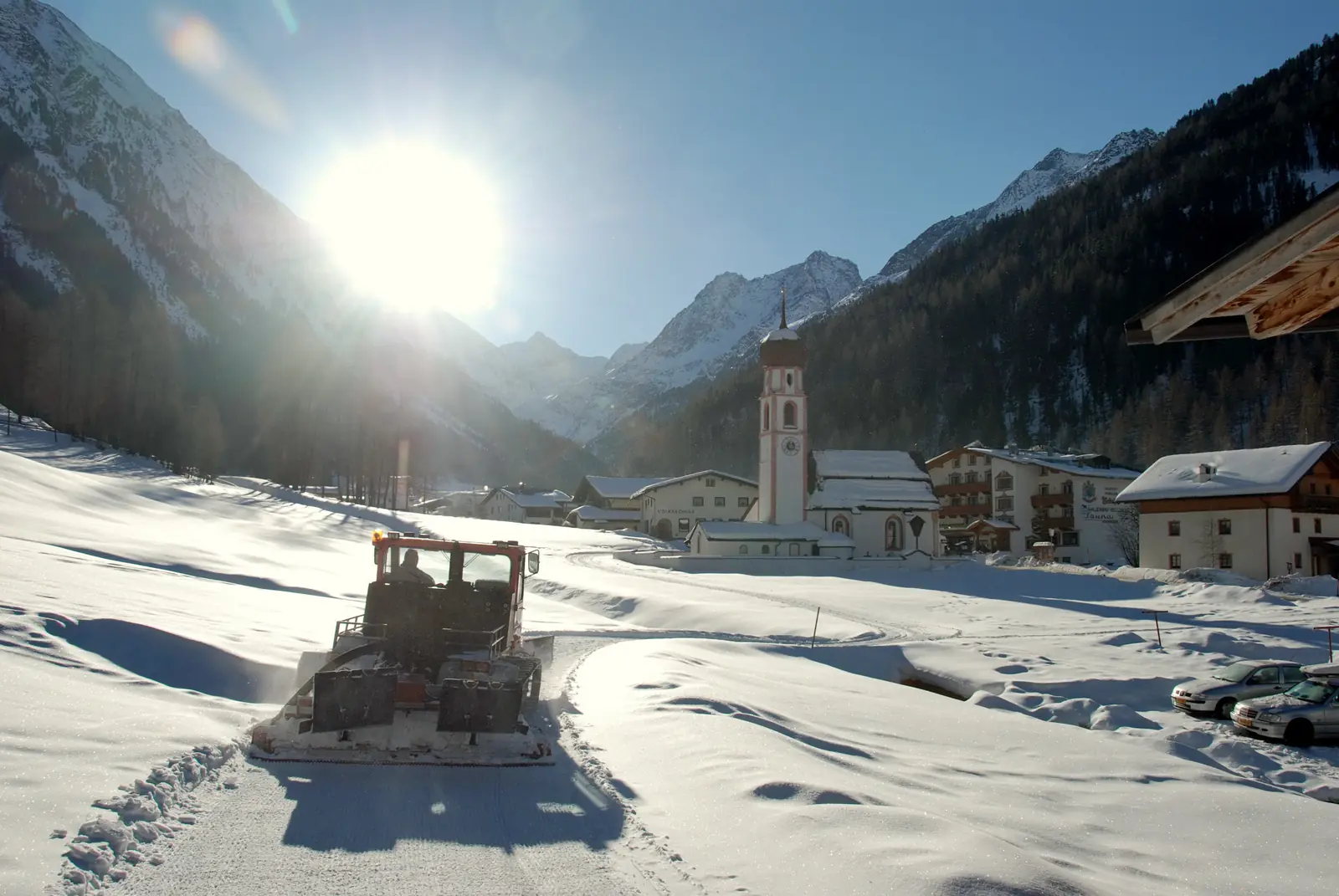Spurgerät präpariert die Loipe am Ortsrand von Gries in Tirol, Gegenlicht